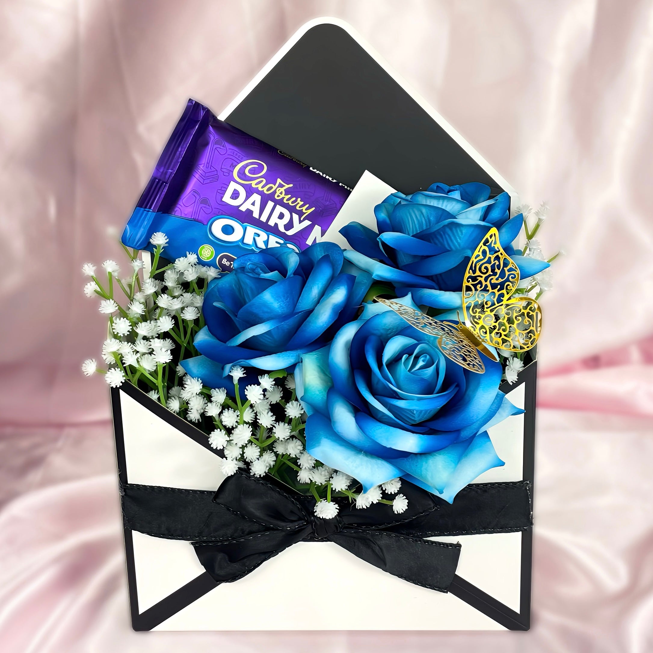 Stunning Envelope Style Chocolate & Flower Arrangement - Inc. Cadbury Oreo Chocolate Bar, 3x Blue Forever Roses & Personalised Postcard